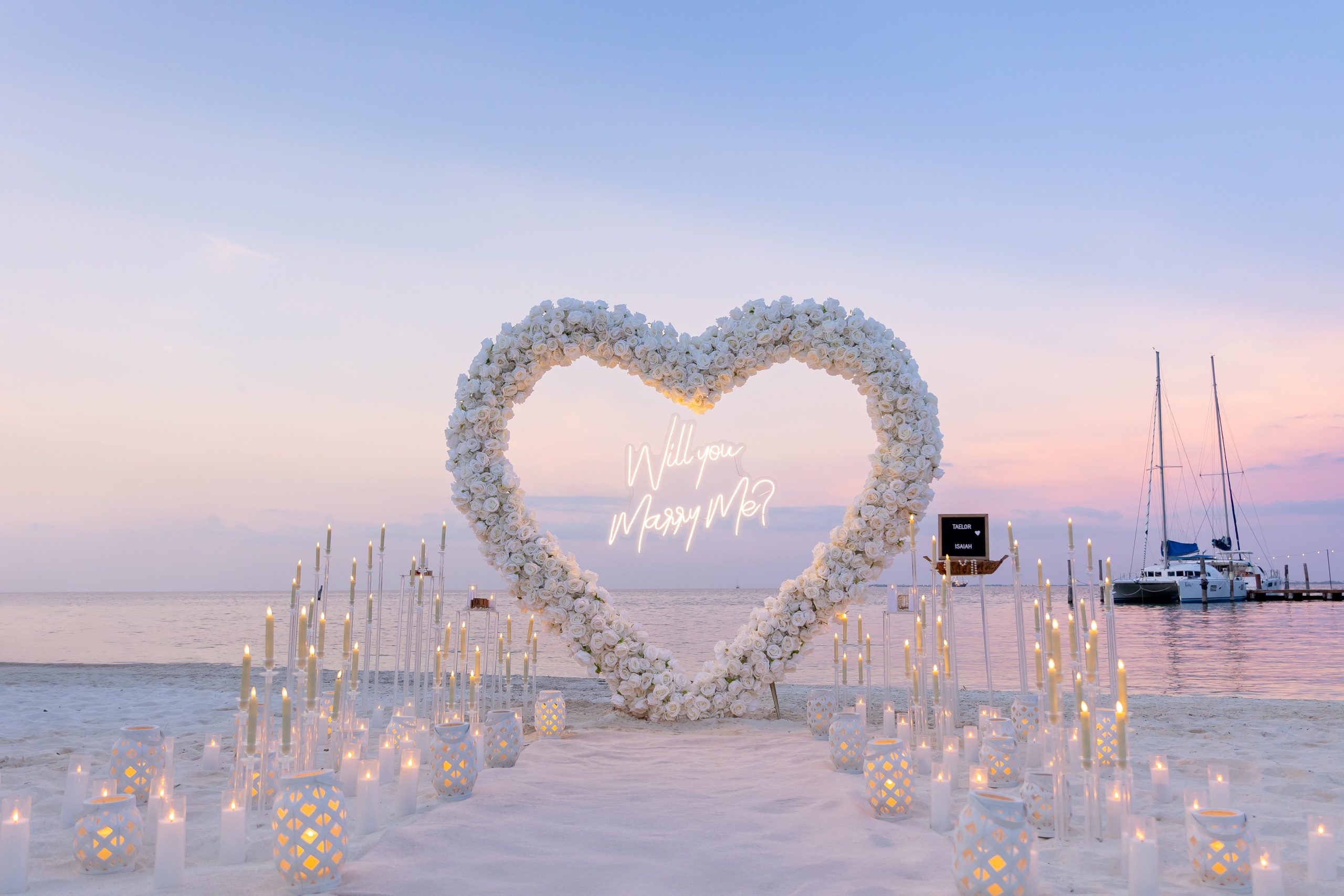 Elegant white rose heart arch with candles and lanterns at Cancun Marina