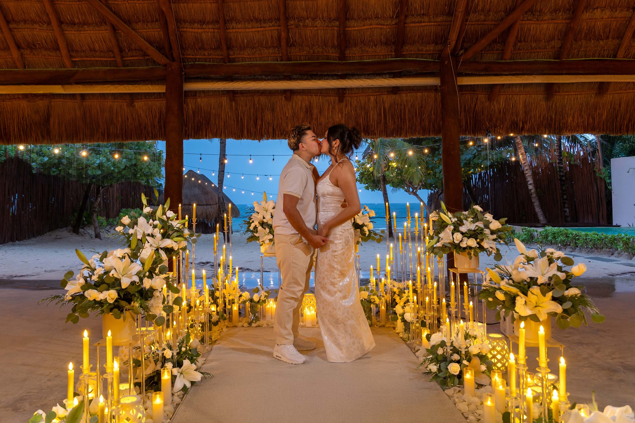 Romantic candlelit beach proposal setup at Acamaya Weddings in Puerto Morelos with couple seated among luxury floral décor