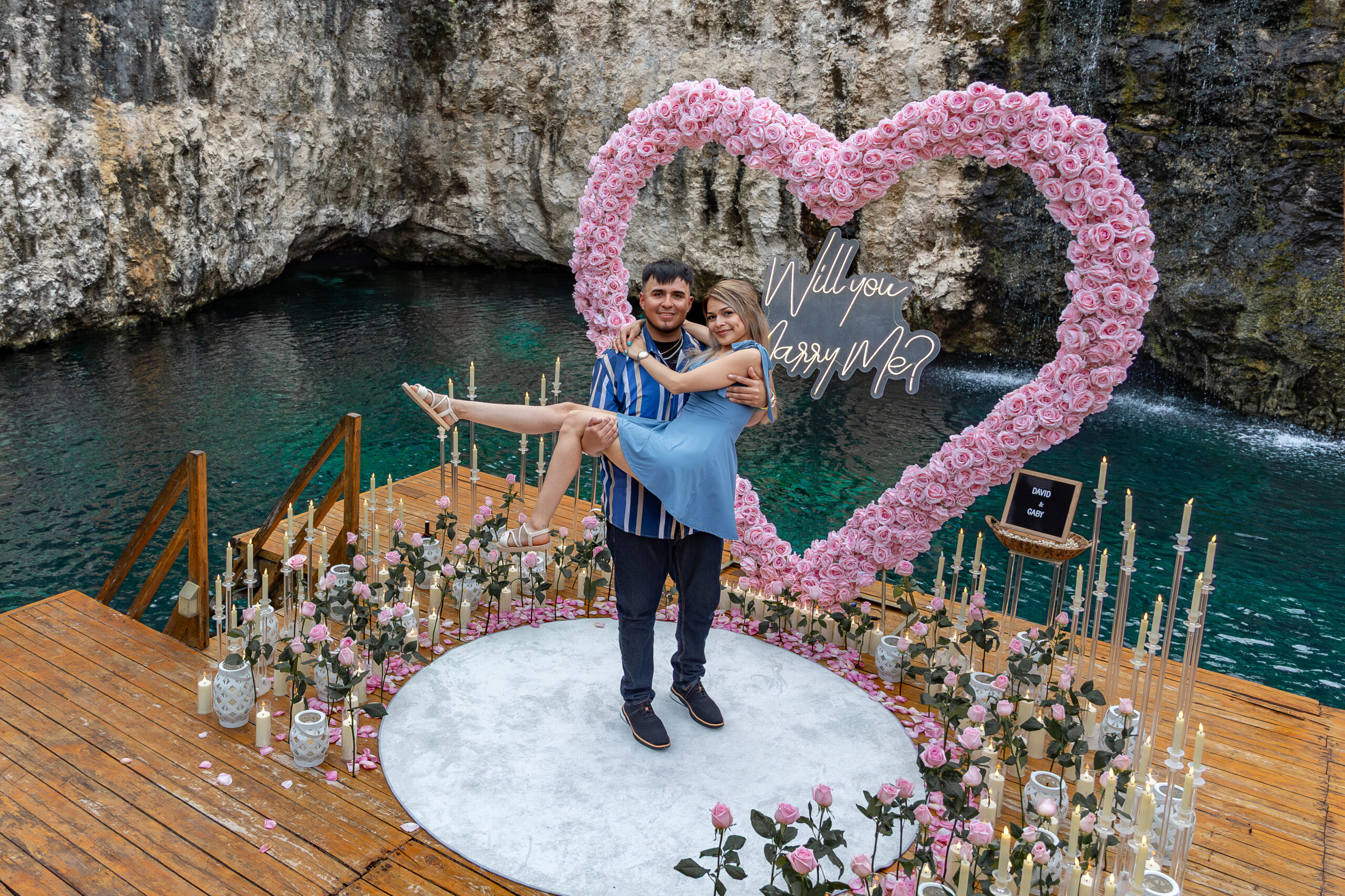 Luxury pink floral proposal beside turquoise cenote water